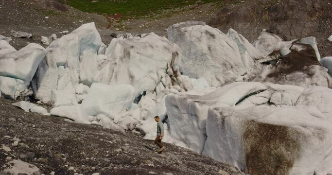 Man walks around the Tustumena glacier in Kenai, Alaska