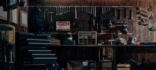 Gordijnen Workshop scène. Oude gereedschappen hangen aan de muur in de werkplaats, gereedschapsplank tegen een tafel en muur, vintage garagestijl © Win