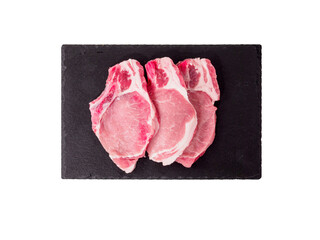 Raw pork steak on black cutting board.