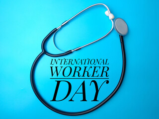 Top view of a stethoscope with the text International Worker Day on a blue background