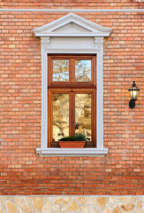 Detail of a wooden window of an elegant urban building with a brick wall