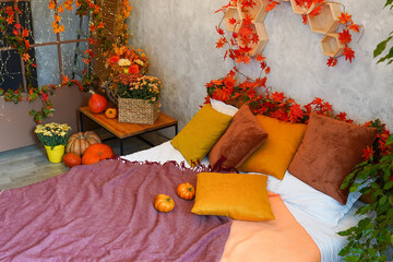 Cozy bedroom interior inspired by autumn colors with decor and pumpkins