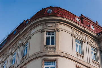 Cornice and windows of a beautiful neoclassical house with a red tiled roof and an attic. European...