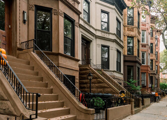 Scenic view of a classic Brooklyn brownstone block with a long facade and ornate stoop balustrade...