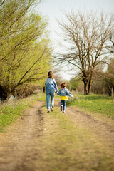 Fototapeta premium Two cute sister girls are running down an empty country road. Spring. Freedom. Childhood. Family.