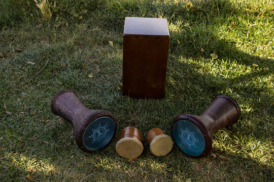 various percussion instruments placed on the grass Peruvian cajón, flamenco cajón, timbales, etc