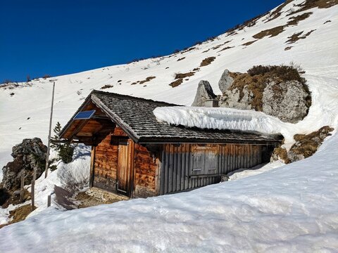 alpine hut in winter. Beautiful old wooden house covered by snow. Picture from the swiss alps. High quality photo
