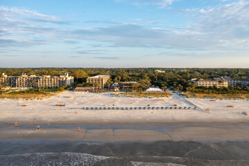 View of Coligny beach on Hilton Head Island.Ocean view at sunset with trees and hotels in foreground - obrazy, fototapety, plakaty