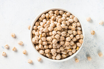 Chickpeas in white bowl at light kitchen table.