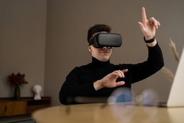 A male freelancer uses virtual glasses presses buttons in the air