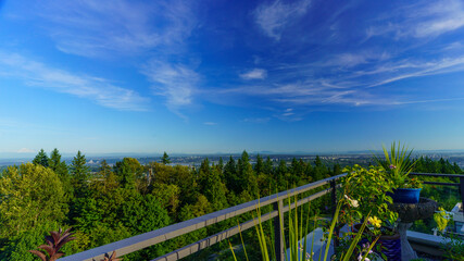 Fototapeta na wymiar Panoramic summer view of BC Lower Mainland with Straits of Georgia and Gulf Islands on far horizon as seen from a Burnaby Mountain rooftop patio garden.