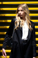 Young women in professional black suit and white blouse. Black and yellow background.