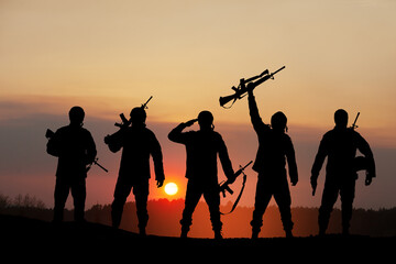 Fototapeta na wymiar Silhouettes of soldiers standing against the backdrop of a sunset. Greeting card for Veterans Day, Memorial Day, Independence Day. USA celebration. Concept - patriotism, protection, remember honor.