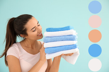 Beautiful young woman with stack of clean towels on blue background. Different color patterns