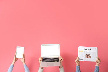 People with newspaper, laptop and tablet computer on pink background