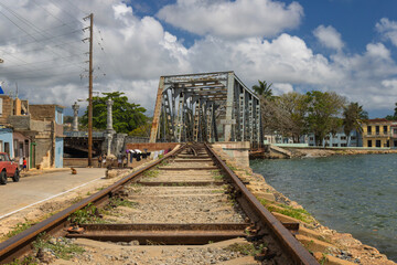 Railway tracks on the shore in Matanzas, Cuba on blue cloudy sky background