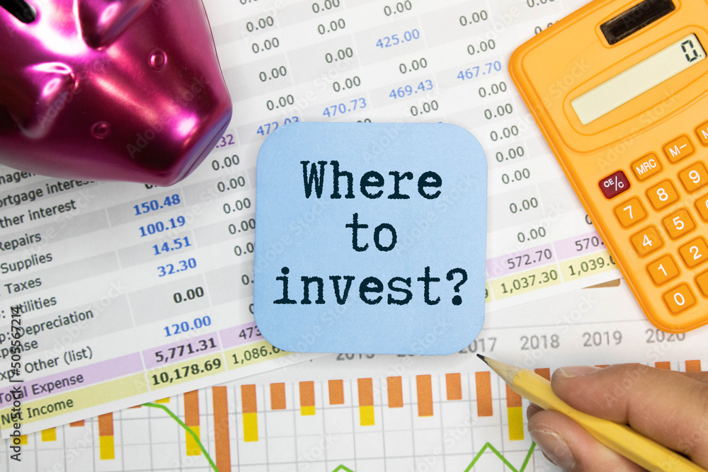 Poster where to invest. light table. text on open notepad