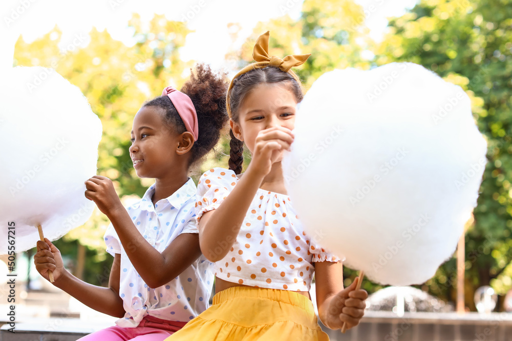 Poster Cute little girls with cotton candy outdoors