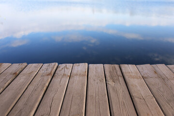 Wooden pier on calm water background