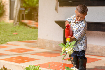Child with down syndrome watering plants in the morning. Caring for the environment and the earth....