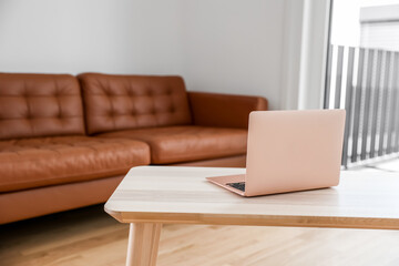 Laptop on wooden coffee table in living room