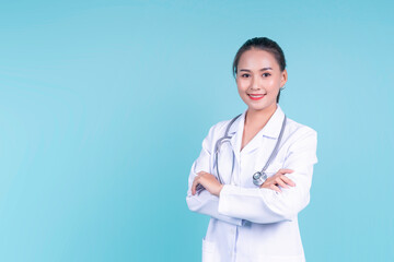 Happy smiling attractive Asian female woman doctor arms crossed confident, medical health care worker scientist clinical specialist expert in lab coat stethoscope, copyspace blue isolated background
