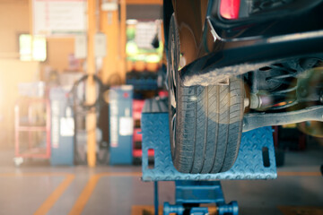 Automobile car repair workshop garage concept, car on elevation lift engineering fixing broken vehicle wheel tyres, work equipment accessories machinery technician repair maintenance motors machine.