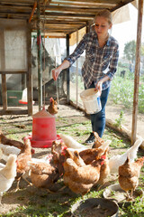 Young woman farmer caring for poultry. High quality photo