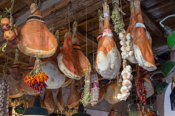 Low-angle shot of hams hanging from the ceiling in a deli, Rome, Italy