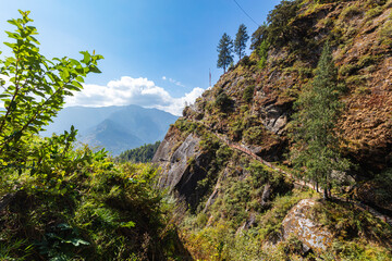 Close to the gorge, the hiking trail to Tiger Nest in the Himalaya mountains Bhutan. Down the steps past the rocks with a view into the valley. Difficult path for monks and tourist to the monastery