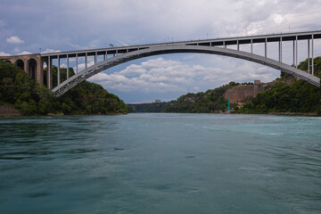 Niagara Falls, Canada - August 27, 2021: The Rainbow Bridge at Niagara Falls is a steel arch bridge that spans the Niagara Gorge. She connects Ontario, Canada and New York, United States.