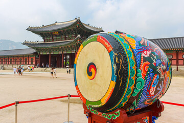 Seoul, South Korea - July 24, 2021: Ceremonial drum in front of the Geunjeongmun Gate and Corridor of Gyeongbokgung Palace. Colourful traditional drum at the square among Gwanghwamun and Geunjeongmun
