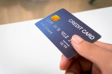 Businessman holding credit card in hand, handing over credit card, showing credit card in hand