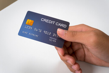 Businessman holding credit card in hand, handing over credit card, showing credit card in hand