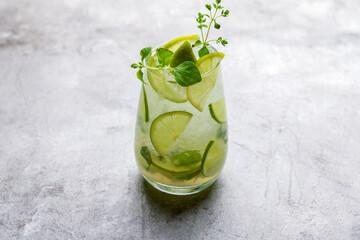 classic Mojito with lime and ice on grey talbe side view