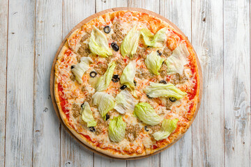 Pizza with tuna and green salad with cheese and tomato sauce top view on white wooden table