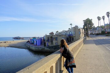 A woman enjoying a beautiful evening with views of Monterey Bay, along the beachfront of Capitola,...