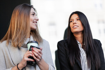 Girls in formal clothes posing outdoors. Businesswomen on a coffee break outdoors..