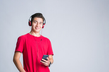 Teenager using his smart phone to entertain himself. Young woman enjoying music on her mobile...