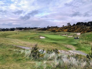A beautiful view of a parkland area with a par 4 golf hole in Bandon, Oregon, with the ocean in the...