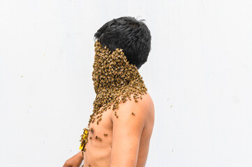 Man's face covered by bees.