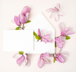 Naklejka na ściany i meble Pink magnolia flower flat lay with the blank stationery invitation card and envelope
