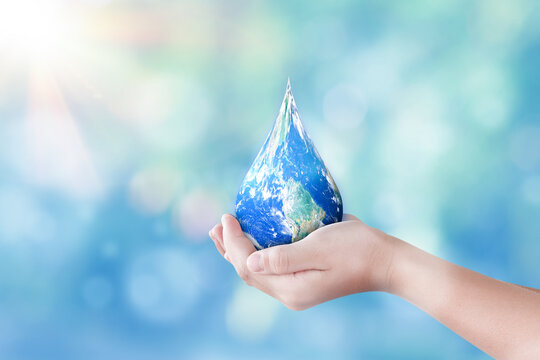 Hands holding global in drop shape on blurred nature background. World day for water and sustain for earth concept. Elements of this image furnished by NASA