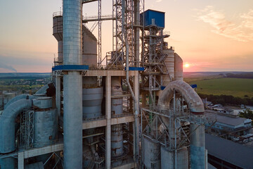 Aerial view of cement factory with high concrete plant structure and tower crane at industrial...