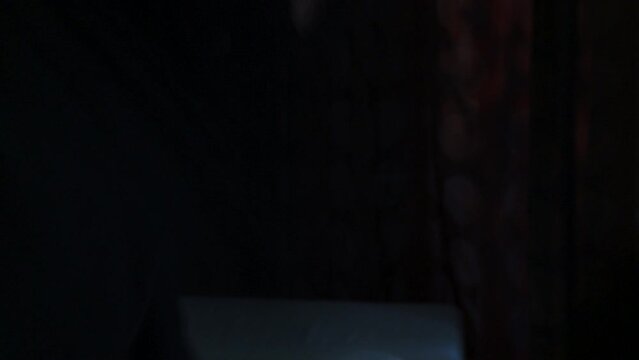 True crime scene- masked serial killer frantically stabbing something of screen in a dark bedroom