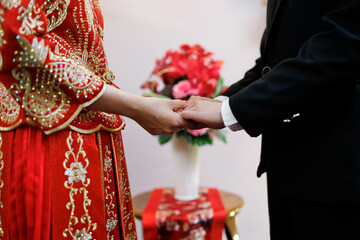 Soft focus image of groom and bride holding hands, traditional Chinese wedding ceremony