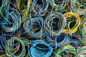 Colorful, coiled copper cables in rubber sheaths. Prepared for further recycling, copper recovery....