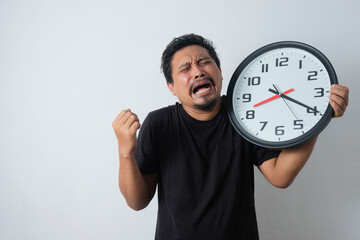 sad asian man crying while holding clock