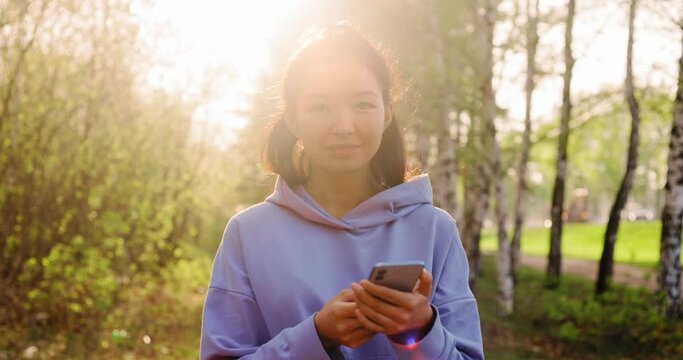 Asian woman using smartphone outdoors