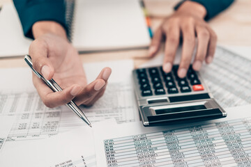 Investors working on desk office and using a calculator to calculate balance, projit, currency and...